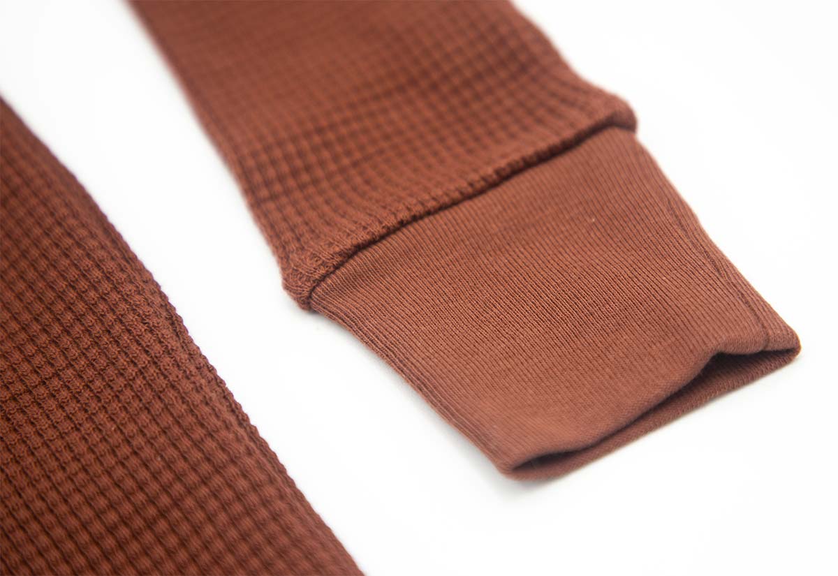 détail de la manche du pyjama enfant en coton pima bio couleur marron foncé
